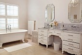 Antique-style chest of drawers with twin sinks and claw-foot bathtub in elegant white bathroom