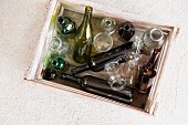 Various empty bottles in a wooden crate (seen from above)