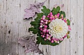 Bouquet with white dahlia and snowberries on rustic wooden surface