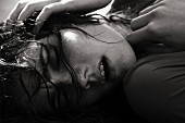 A young woman with wet hair lying down (black-and-white shot)