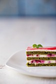 A slice of matcha cake with raspberry cream filling