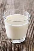 A glass of milk on a wooden surface