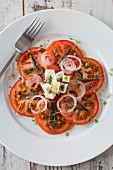 Tomato salad with anchovies, feta cheese, onions and capers