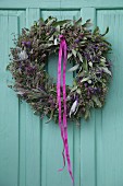Wreath of lavender and sage hung on turquoise wooden door