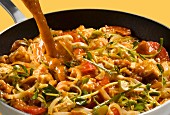 Currysauce auf Paneer mit Sprossen und roten Paprikaschoten gießen