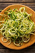 Courgette noodles on a wooden plate