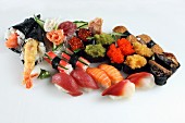 Viele verschiedene Sushi auf weißem Untergrund