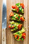 Bread corners topped with guacamole and tomatoes