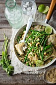 Thai fish dish with green beans, peas and cashew nuts on a bed of couscous
