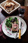 Pâté en croute with a mixed leaf salad, bread and red wine