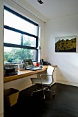 Classic office chair at desk below window in study
