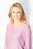 A blonde woman wearing a lilac jumper with Lurex and sequins