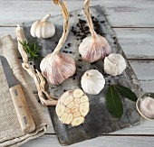 Garlic (purple and white) and bay leaves on a wooden board