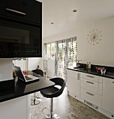 Schwarz-weiße Küche, umlaufende Theke mit schwarzer Granitplatte, Küchenzeile mit weisser Hochglanzfront