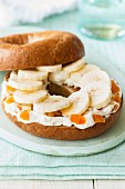 A bagel with quark, dried apricots, and sliced banana
