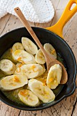 Warm bananas slices with orange syrup