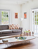 Classic coffee table in front of grey couch and white standard lamp in corner of living room