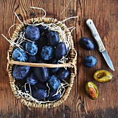 Plums in a rustic basket and next to it