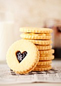 A stack of jam and cream sandwich biscuits with heart-shaped windows