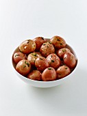 Rote Babykartoffeln als Pellkartoffeln im Schälchen