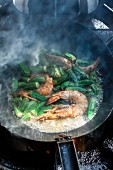 Prawns with okra pods being fried in a pan in a kitchen at the Machane-Jehuda market, Jerusalem