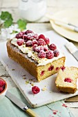 Raspberry cake with icing sugar and pistachios, sliced