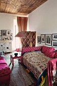 Comfortable daybed with ethnic blanket and pink cushions in eclectic ambiance