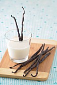 A glass of milk with vanilla pods