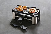 A raclette for two pans with a grill