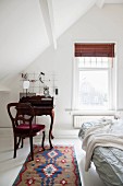 Antique bureau and chair in attic bedroom