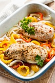 Chicken breast on a pepper medley in a baking dish