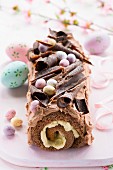 An Easter chocolate log cake with chocolate cream and Easter eggs