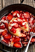 Baked Camembert in strawberry sauce with pomegranate seeds and flaked almonds
