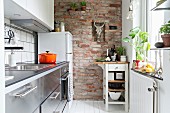 Brick wall and serving trolley in narrow kitchen