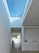 weiße Küchenzeile und Flurbereich mit grossem Oberlicht und blauem Himmel