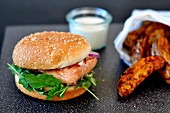A salmon burger with potato wedges