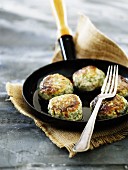 Fish meatballs with chilli and dill in a frying pan