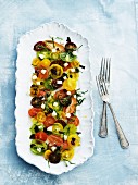 Colourful tomato salad with olives, diced mozzarella and basil