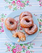 Sugared doughnuts on a floral-patterned plate