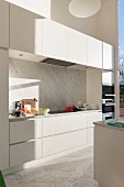 Moderne weiße Küche mit Marmor- Spritzschutz und Marmorboden