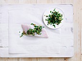 Rohes Fischfilet mit Oliven-Zitronen-Salsa auf Papier