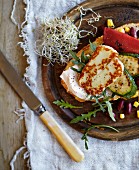 Bread topped with halloumi, peppers, sweetcorn, pumpkin, rocket and beansprouts