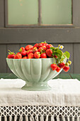 Freshly picked strawberries in a white bowl on a table