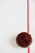 A chocolate muffin with chocolate chips (seen from above)
