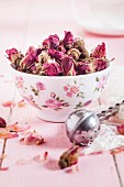 Bowl of dried Moroccan rosebuds and tea infuser for making rose tea