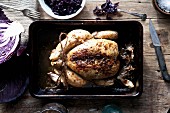 Oven-roasted chicken in a baking tin with a red cabbage medley (seen from above)