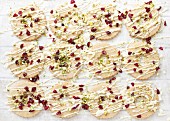 Ring biscuits decorated with white chocolate, cranberries and pistachio nuts