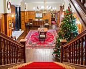 Blick von der Treppe auf herrschaftlichen Saal mit Weihnachtsbaum