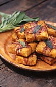 Polenta slices wrapped in bacon with sage