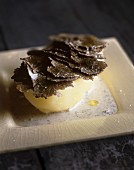 A new potato topped with truffle slices